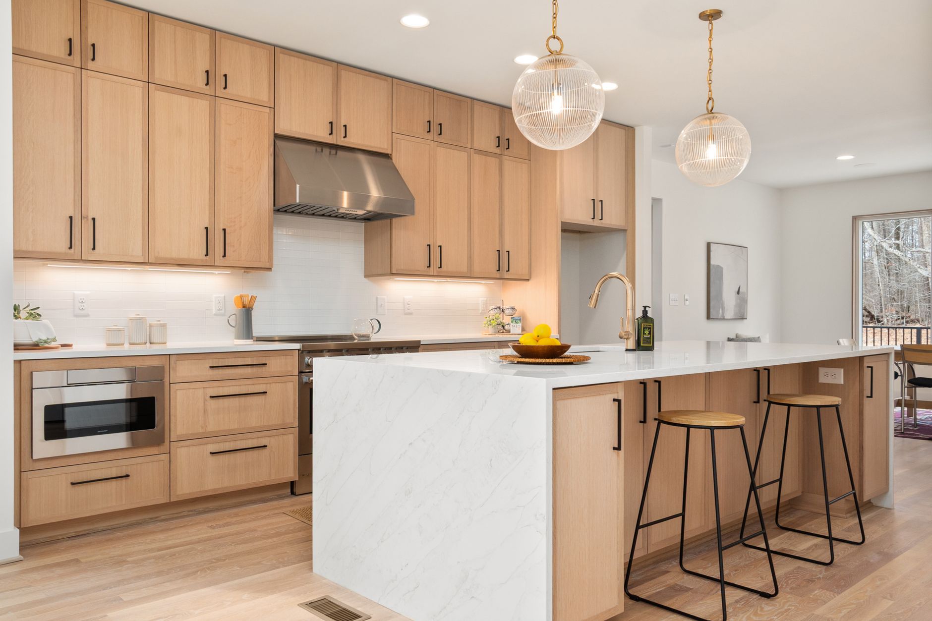 Kitchen — White oak, honed limestone, and unlacquered brass that will patina with the cooking.